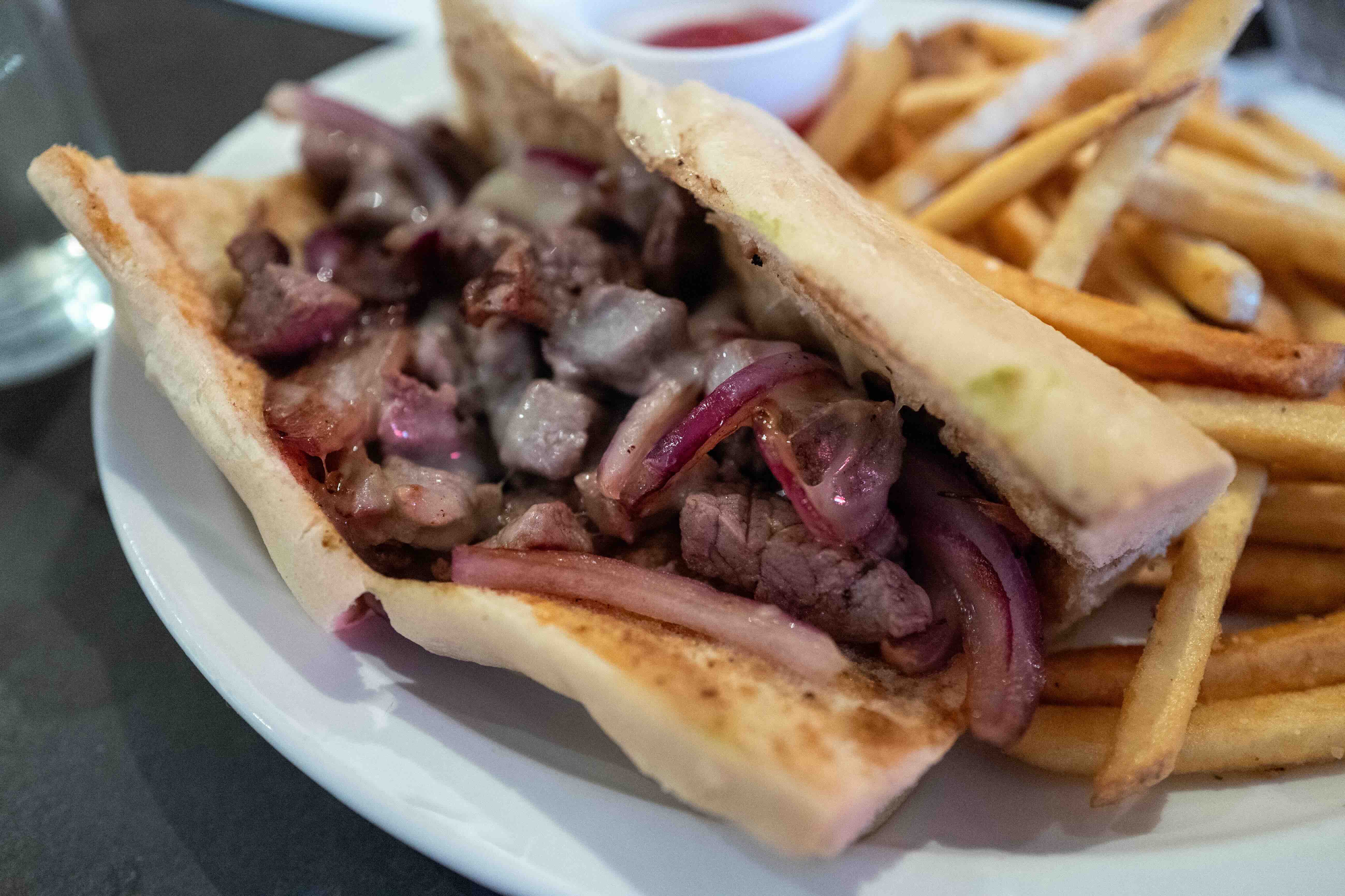 Close-up of cheesesteak with French fries at Grounds restaurant, Murphys, California, August 2, 2025. (Photo by Smith Coll...