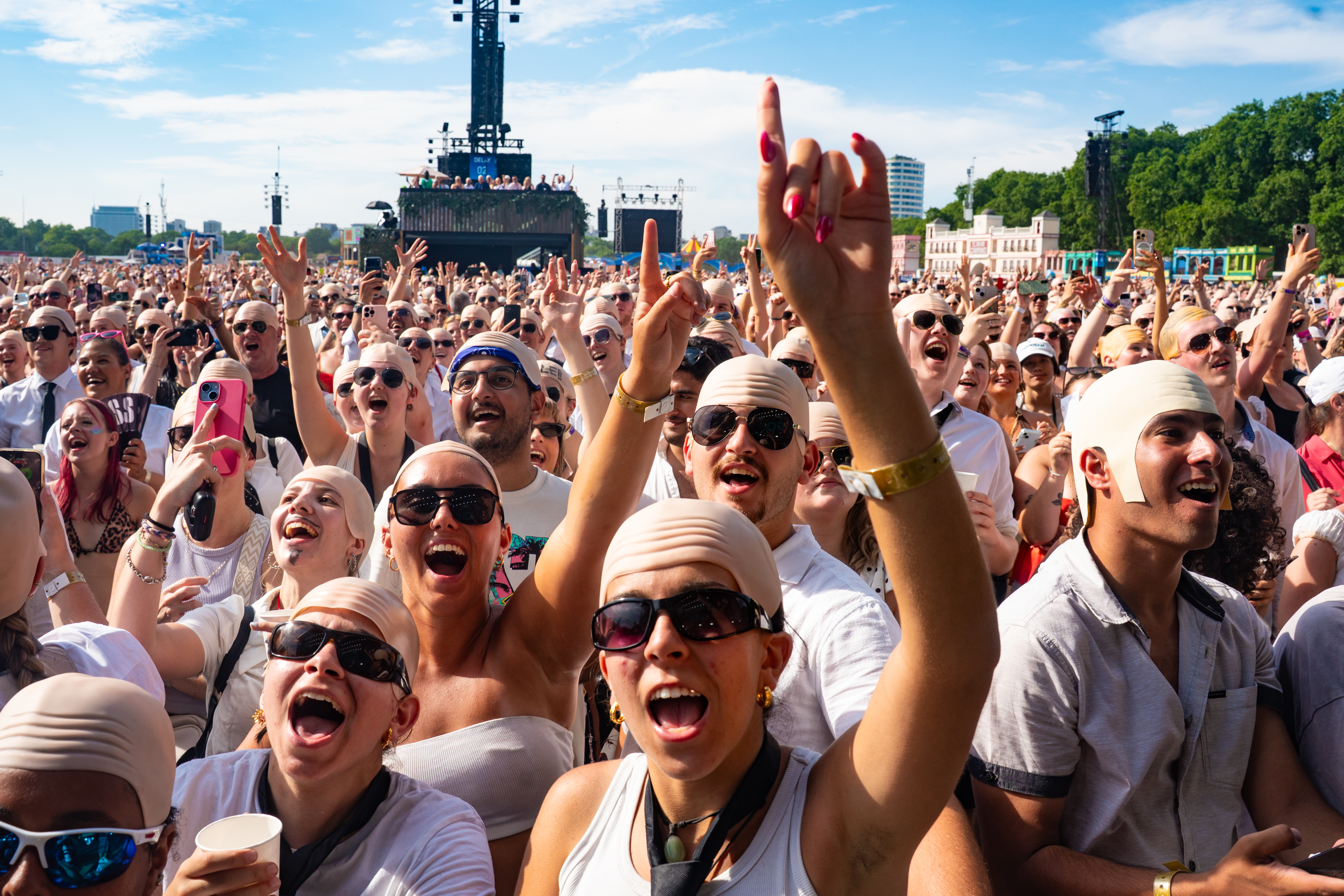 LONDON, ENGLAND - JULY 10: Fans dressed up in bald caps and Pitbull's signature style of suits and sunglasses take part in...